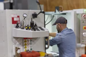 Man operating a 5-axis CNC machine at the Autodesk Technology Center Boston.