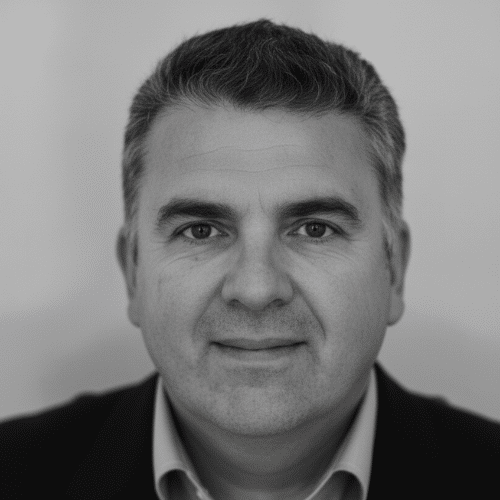 Portrait of a middle-aged man with short hair, wearing a suit, in black and white.